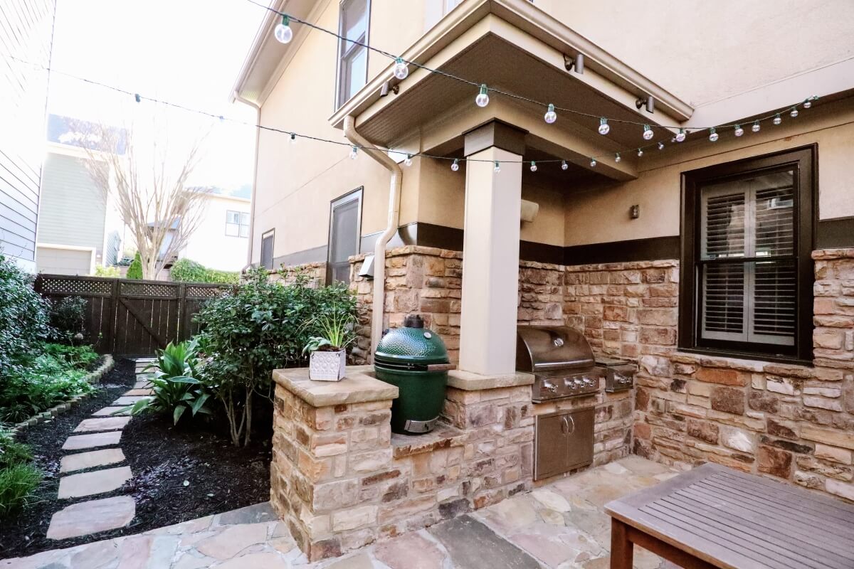 outdoor kitchen and living space with steel grill and big green egg